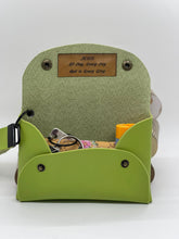 Load image into Gallery viewer, Green bag with a brown patch and compartments on a white background