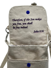 Load image into Gallery viewer, Cross-body bag with Bible scripture (John 8:36) written on a plain background of the inside flap
